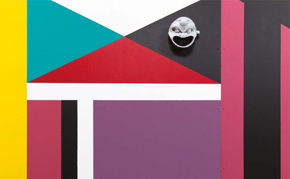 Colourful abstract painting with sculpture of face in top righthand corner